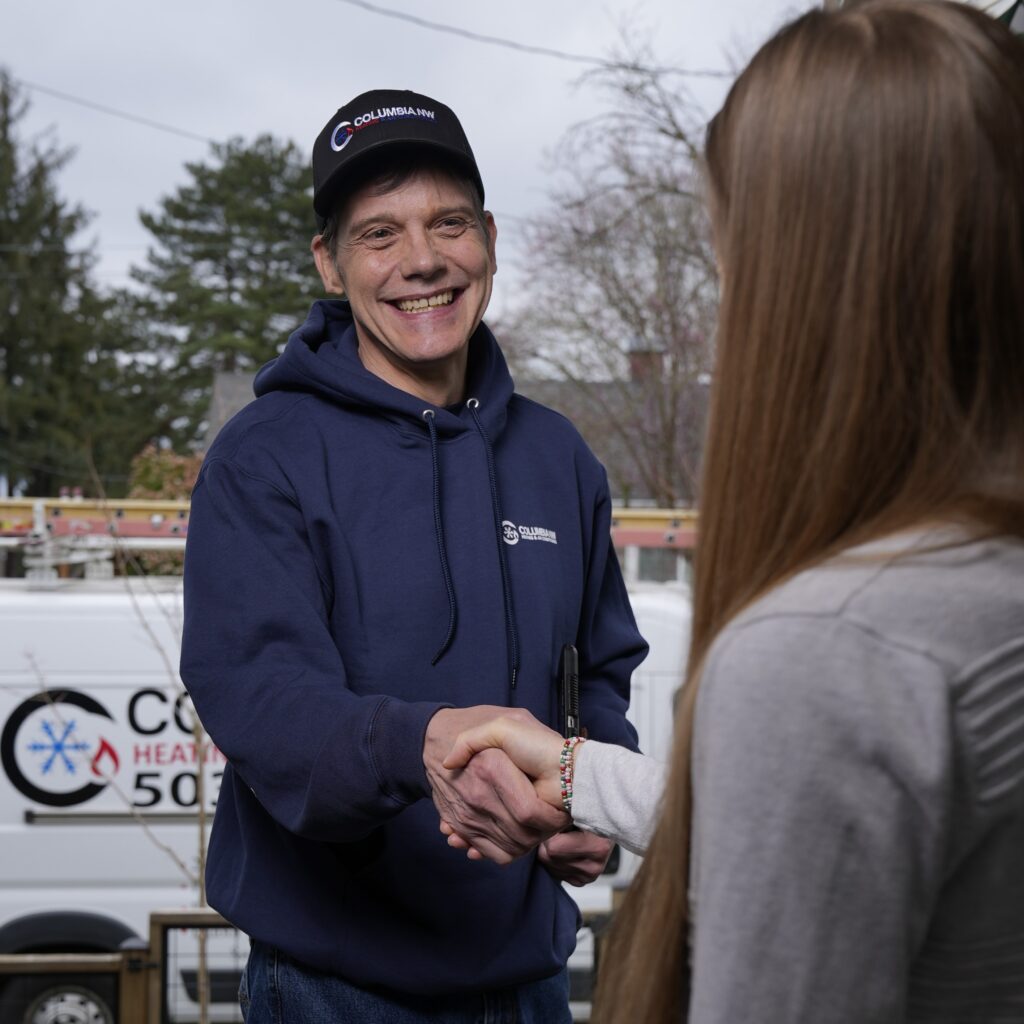 Columbia Northwest tech shaking hands with a homeowner