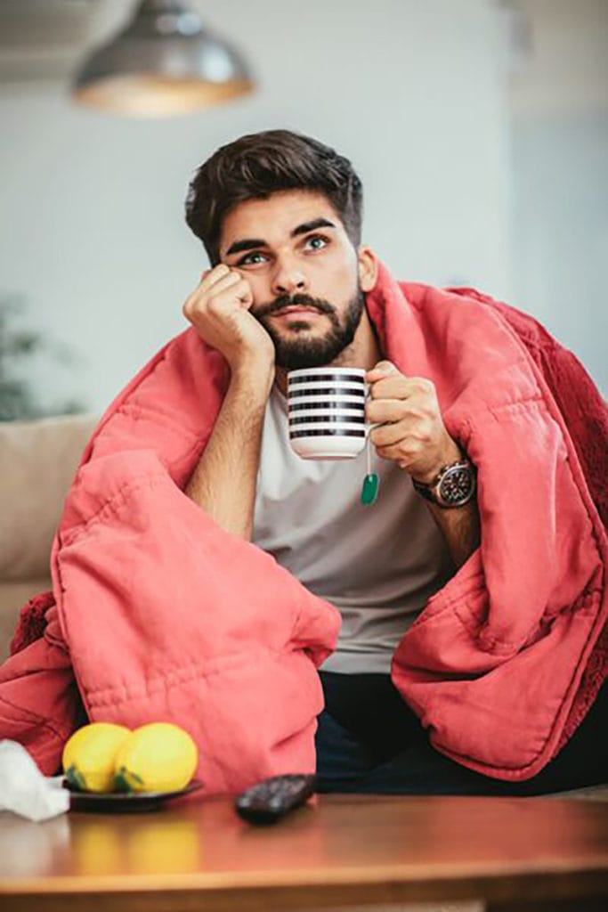 Cold Man on Couch With Blanket